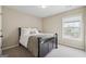 Cozy bedroom with a black bed frame, neutral paint, carpet and a window offering lots of light at 6448 Mobilis Ct, Sugar Hill, GA 30518