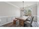 Dining room features gray walls, crown molding, a window with natural light, and a rustic dining set at 6448 Mobilis Ct, Sugar Hill, GA 30518