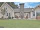 Back patio with stone fireplace and wood chairs overlooks green lawn at 676 Mcbride Rd, Fayetteville, GA 30215