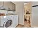 Convenient laundry room with a washer, dryer and built-in upper cabinets for storing supplies at 676 Mcbride Rd, Fayetteville, GA 30215