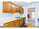 Practical kitchen showcasing wood cabinets, stainless steel sink, and adjoining living space at 1099 Westfield Se Trce, Smyrna, GA 30082