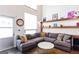 Open-concept living room with a large sectional sofa and rustic wooden shelving for storage and decor at 1661 La France Street Ne Unit #216, Atlanta, GA 30307