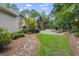 Lush backyard with a rock garden, expansive lawn, and covered patio, perfect for outdoor entertaining at 107 Calloway Xing, Peachtree City, GA 30269