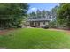 Landscaped backyard with a manicured lawn, mature trees, and meticulously maintained foliage around the home at 107 Calloway Xing, Peachtree City, GA 30269