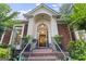 Elegant front entrance featuring brick steps, black railing, and an arched transom window at 107 Calloway Xing, Peachtree City, GA 30269