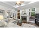 Well-lit living room with fireplace, large windows, and a view into the kitchen and dining area at 107 Calloway Xing, Peachtree City, GA 30269