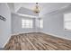 Bedroom featuring wood-look flooring, large windows, tray ceiling, and a chandelier at 269 Legends Trce, Mcdonough, GA 30253