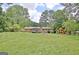 Large grassy backyard featuring a patio, playset, and brick home at 260 Sharon Dr, Fayetteville, GA 30214