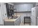 Traditional kitchen with stainless steel sink, gray cabinets, tiled backsplash, and refrigerator at 250 Jonesboro Rd, Jonesboro, GA 30236