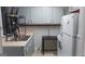 Traditional kitchen with stainless steel sink, gray cabinets, tiled backsplash, and refrigerator at 250 Jonesboro Rd, Jonesboro, GA 30236