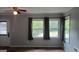 Bright living room featuring plush carpeting, neutral walls, and three windows offering natural light at 250 Jonesboro Rd, Jonesboro, GA 30236
