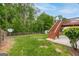 Spacious backyard featuring green grass, a small shed, and a wooden deck with stairs at 980 Charter Club, Lawrenceville, GA 30043