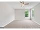 Bright bedroom featuring neutral walls, plush carpet, ceiling fan, and a pair of windows at 980 Charter Club, Lawrenceville, GA 30043