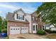 Two-story brick and vinyl home with a two-car garage, bay windows, and professional landscaping at 980 Charter Club, Lawrenceville, GA 30043