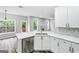 Open kitchen featuring white cabinets, quartz countertops, stainless steel appliances and views to the living room at 980 Charter Club, Lawrenceville, GA 30043