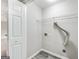 Bright laundry room features gray wood-look flooring, shelving, and a white door, perfect for efficient home management at 980 Charter Club, Lawrenceville, GA 30043