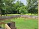 Spacious backyard view from deck, showcasing lawn area, mature trees, and privacy fence at 223 Overland Trl, Mcdonough, GA 30252