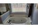 Inviting bathroom features a large soaking tub with chrome fixtures and a window at 223 Overland Trl, Mcdonough, GA 30252