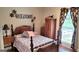 Well-lit bedroom showcases a wood frame bed, side table, wardrobe, and a bright window at 223 Overland Trl, Mcdonough, GA 30252