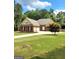 Traditional brick home with well-maintained lawn, mature landscaping, and a long driveway to attached garages at 223 Overland Trl, Mcdonough, GA 30252