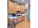 Well-equipped kitchen with stainless steel dishwasher and sink, neutral countertops and ample wooden cabinets at 223 Overland Trl, Mcdonough, GA 30252