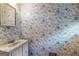Bathroom with decorative wallpaper, single sink vanity, and neutral color palette at 115 Fernway Dr, Fayetteville, GA 30214