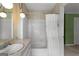 Bathroom featuring white tile, shower-tub, marble counter, and vintage light fixture at 115 Fernway Dr, Fayetteville, GA 30214