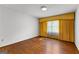 Bright bedroom featuring hardwood floors and sunny window with yellow draperies at 115 Fernway Dr, Fayetteville, GA 30214