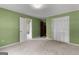 Spacious green bedroom with closet, carpeting, and access to other rooms at 115 Fernway Dr, Fayetteville, GA 30214