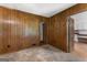 Bedroom with wood paneling, carpet, and a view into the kitchen at 115 Fernway Dr, Fayetteville, GA 30214