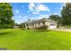 Charming one-story brick home with a well-maintained lawn, mature trees, and an attached garage, offering classic curb appeal at 115 Fernway Dr, Fayetteville, GA 30214
