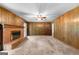 Living room with fireplace and wooden paneled walls and carpeted flooring at 115 Fernway Dr, Fayetteville, GA 30214