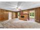 Spacious living room with fireplace and wooden paneled walls and carpeted flooring at 115 Fernway Dr, Fayetteville, GA 30214