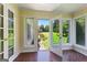 Sunroom with doors to the back yard, brick accents, tile flooring, and many windows at 115 Fernway Dr, Fayetteville, GA 30214