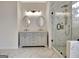Bright bathroom features a glass shower with marble-style tile, dual vanity and modern lighting fixtures at 332 Aster Ridge Trl, Peachtree City, GA 30269
