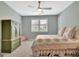 Bedroom with ceiling fan, hardwood flooring, and patterned bedding at 332 Aster Ridge Trl, Peachtree City, GA 30269