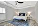 Bright bedroom features a patterned area rug, modern ceiling fan and stylish lamps on both sides of the bed at 332 Aster Ridge Trl, Peachtree City, GA 30269