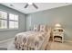 Bedroom with ceiling fan, hardwood flooring, and patterned bedding at 332 Aster Ridge Trl, Peachtree City, GA 30269