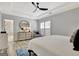 Bright bedroom features a ceiling fan, stylish round mirror, and ensuite bathroom with a glass shower at 332 Aster Ridge Trl, Peachtree City, GA 30269