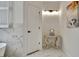 Hallway featuring marble tile, a side table with decor, leading to a door and access to the bathroom at 332 Aster Ridge Trl, Peachtree City, GA 30269