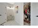 Hallway featuring marble tile, a side table with decor, and a doorway to a closet with open shelving at 332 Aster Ridge Trl, Peachtree City, GA 30269