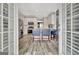 View through French doors of the bright kitchen with stainless appliances and eat-in island with blue barstools at 332 Aster Ridge Trl, Peachtree City, GA 30269