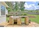 Outdoor kitchen with stone base and countertop, perfect for outdoor gatherings, overlooks landscaped backyard at 332 Aster Ridge Trl, Peachtree City, GA 30269