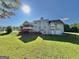Spacious backyard featuring a large lawn, deck, screened-in porch, with mature trees on a sunny day at 116 Cardell Farms Rd, Locust Grove, GA 30248