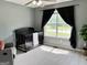 Bright Bedroom with a crib, gray recliner, and a window with outdoor views at 116 Cardell Farms Rd, Locust Grove, GA 30248