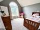 Bright bedroom features a large window, vaulted ceiling, and a charming dollhouse at 116 Cardell Farms Rd, Locust Grove, GA 30248