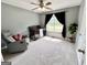 Comfortable Bedroom featuring a crib, recliner, and window with dark curtains at 116 Cardell Farms Rd, Locust Grove, GA 30248