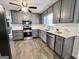 Well-appointed kitchen featuring stainless steel appliances, gray cabinetry, white countertops, and modern flooring at 116 Cardell Farms Rd, Locust Grove, GA 30248