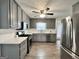 Modern kitchen featuring gray cabinets, stainless steel appliances, granite counters, and new flooring at 116 Cardell Farms Rd, Locust Grove, GA 30248