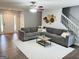 Spacious living room featuring a sectional sofa, neutral colors, and a staircase at 116 Cardell Farms Rd, Locust Grove, GA 30248